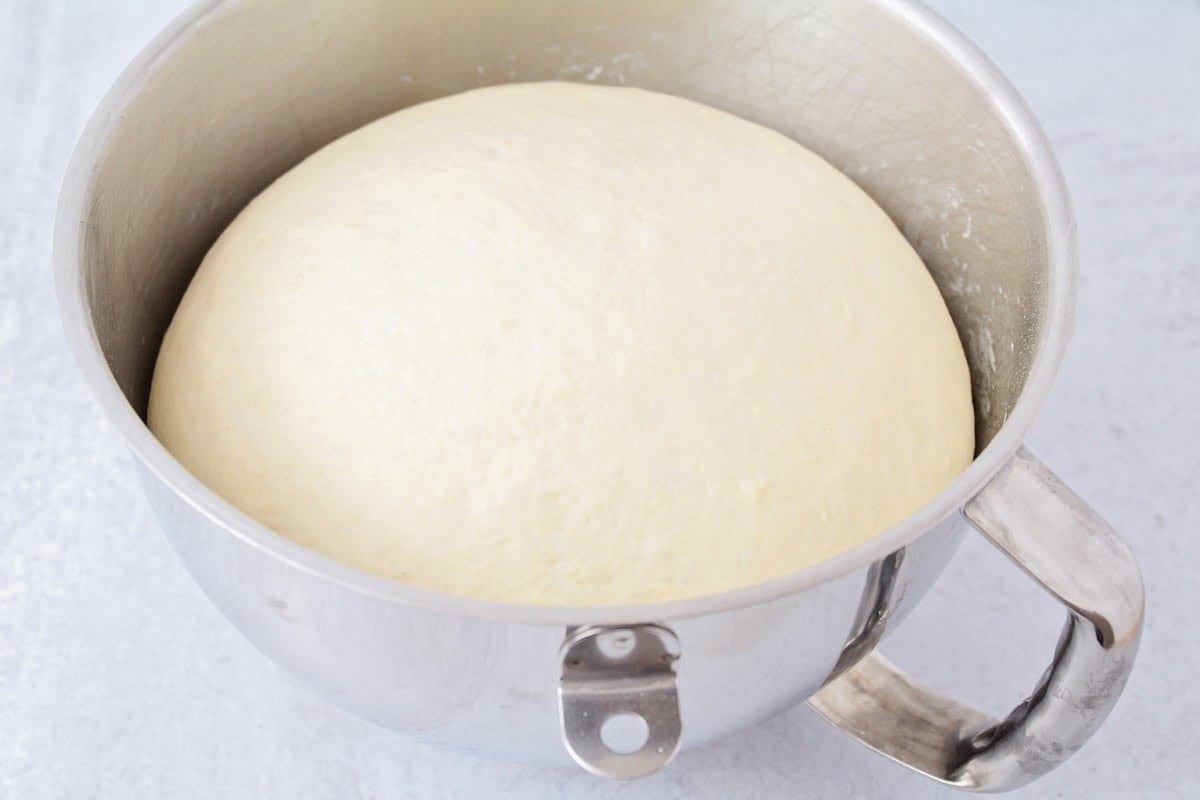 Dough rising in a metal bowl.