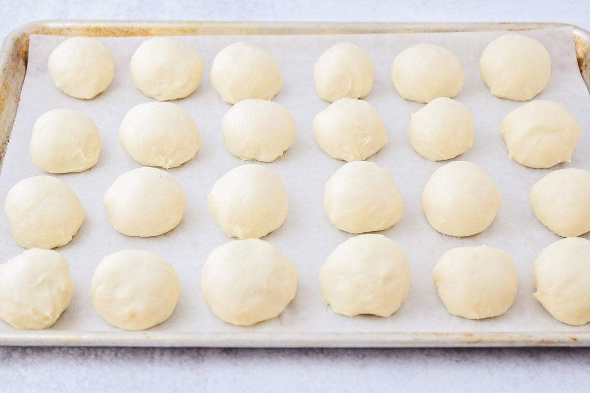 Potato rolls dough on parchment paper lined baking sheet.