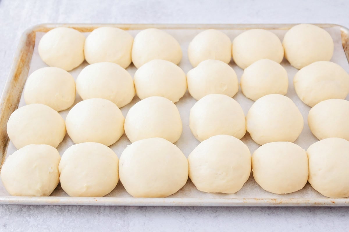 Shaped rolls on a line baking sheet.