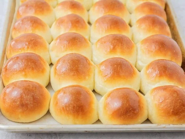Potato rolls baked to perfection on baking sheet.