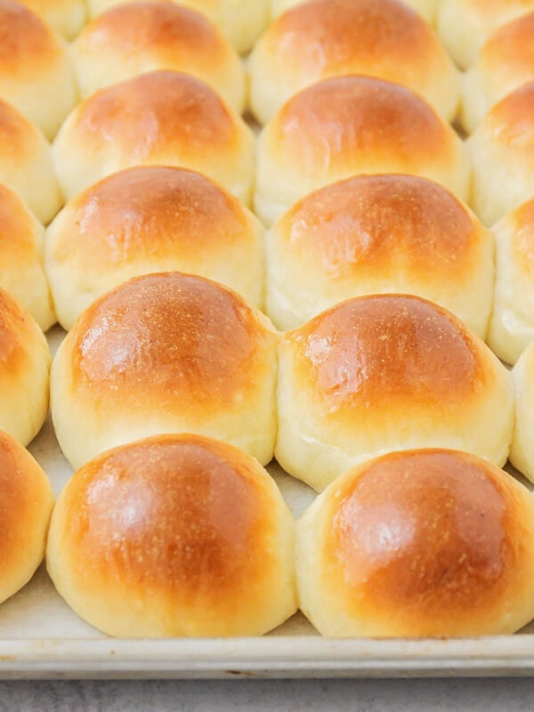 Potato rolls baked to perfection on baking sheet.