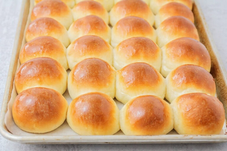 Potato rolls baked to perfection on baking sheet.
