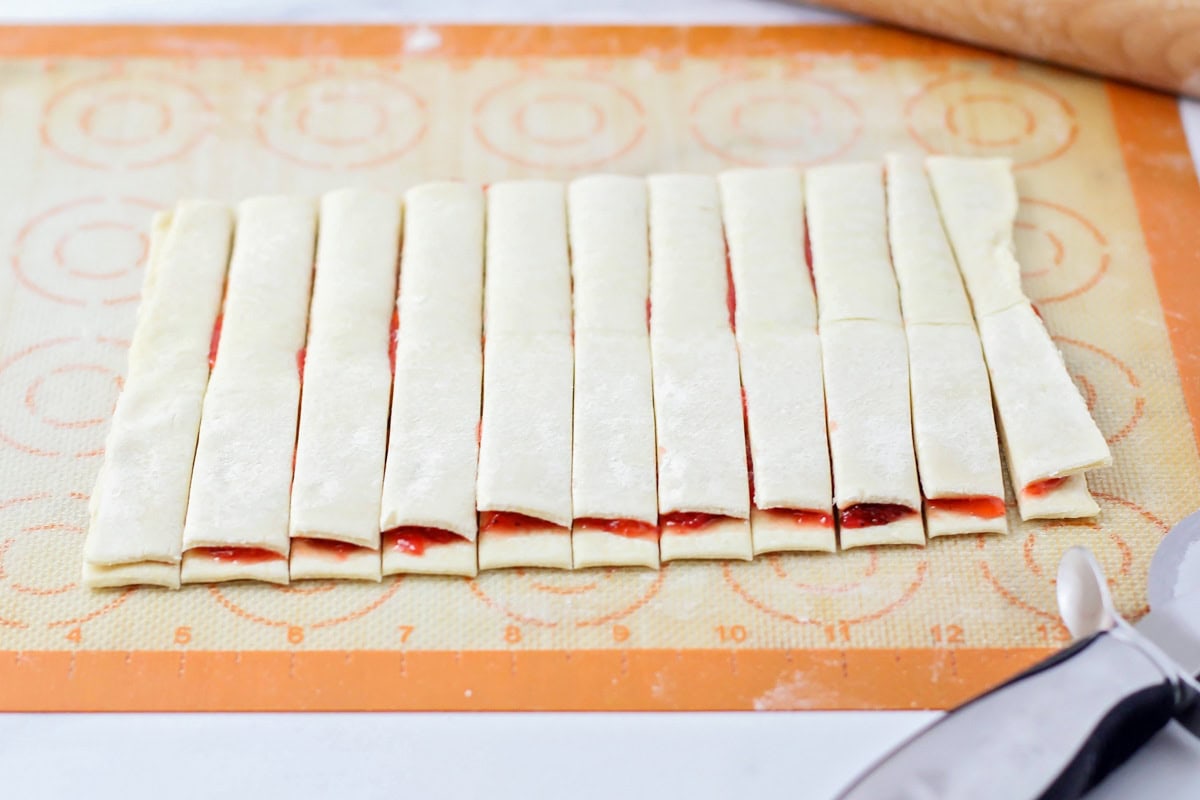 Cutting puff pastry into strips.