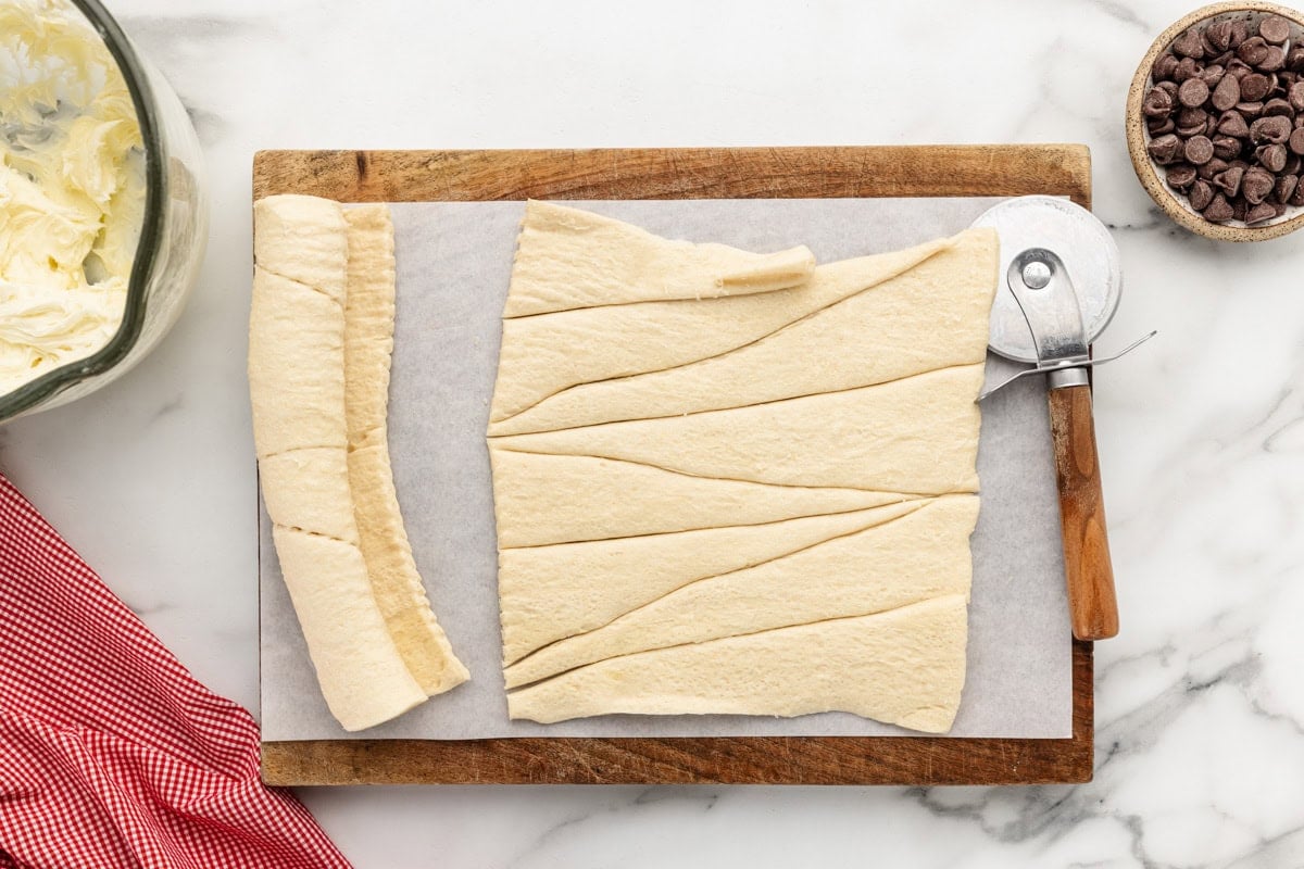 Cutting crescent roll dough into strips.