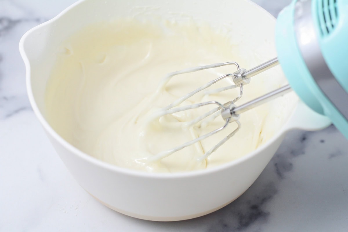 Cream cheese frosting mixed together in mixing bowl.