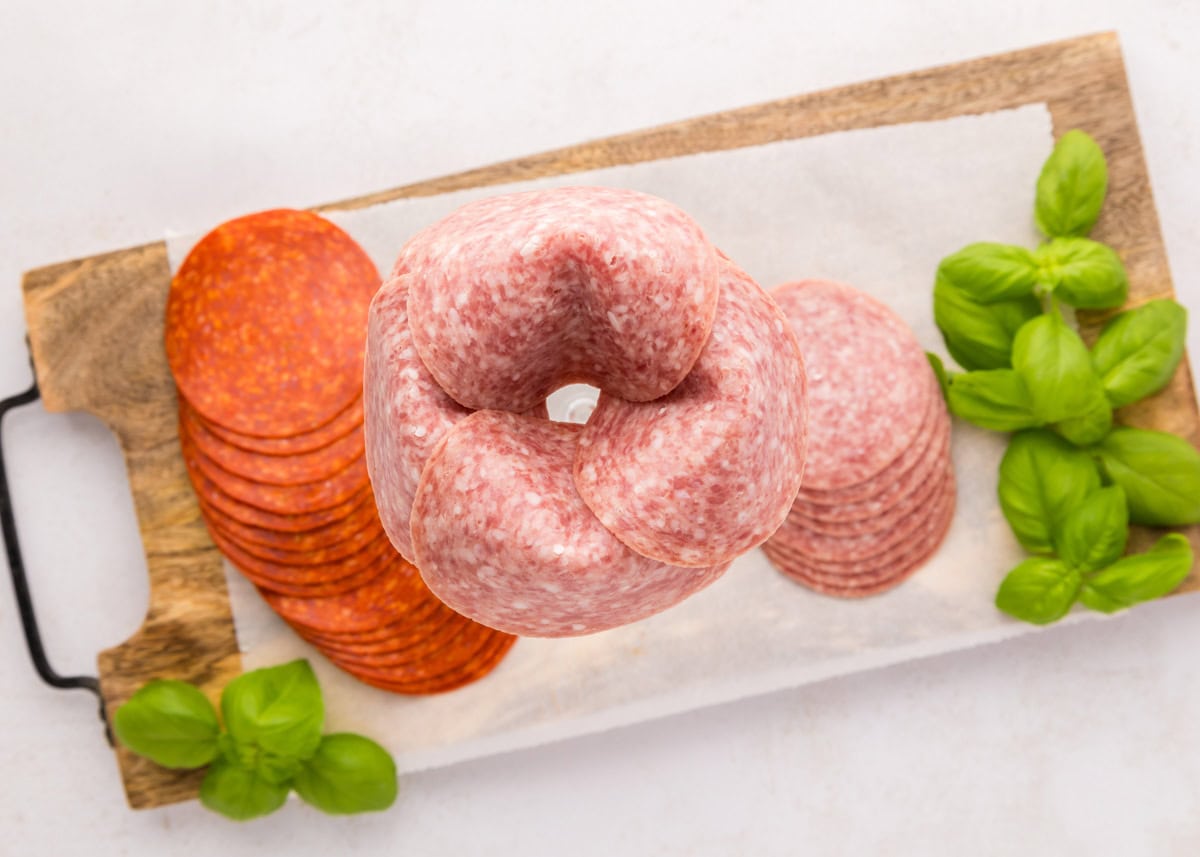 Folding salami over the rim of a glass.