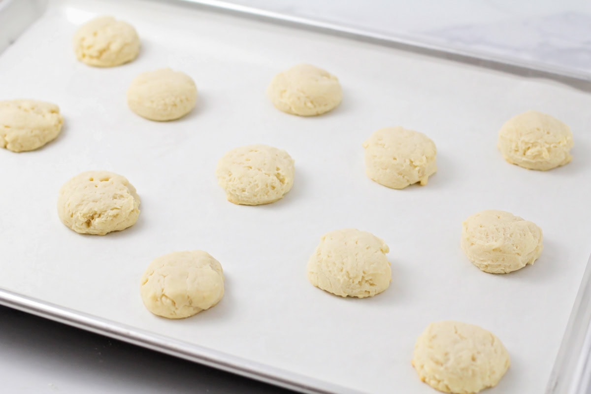 Several baked cookies on a lined baking sheet.