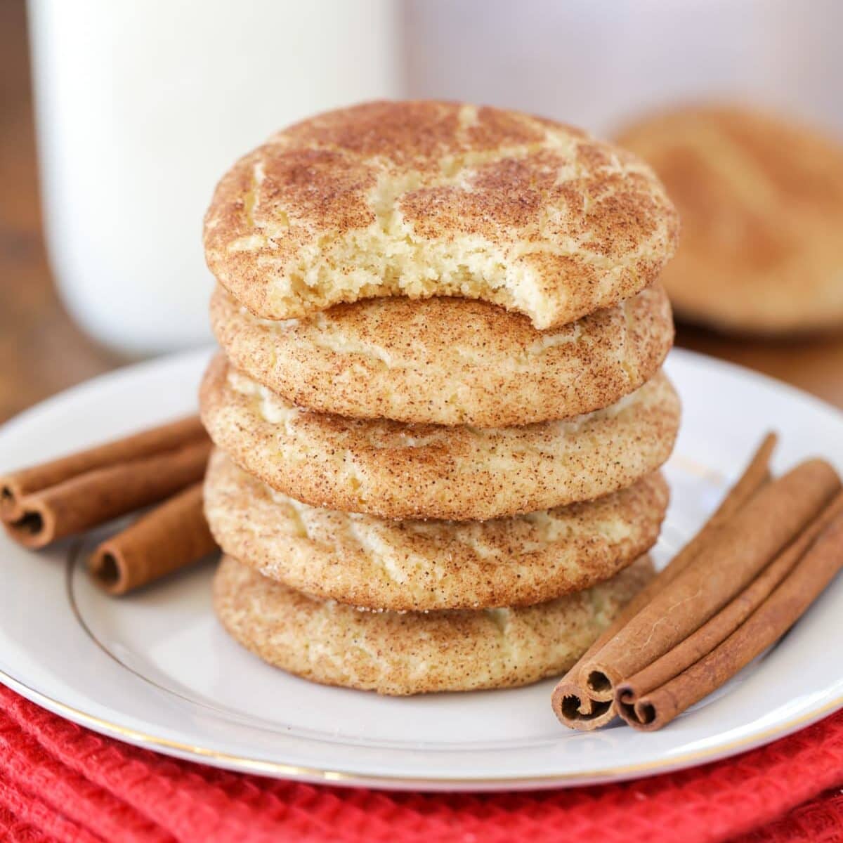 Snickerdoodle cookies stacked on top of each other with bite taken out.