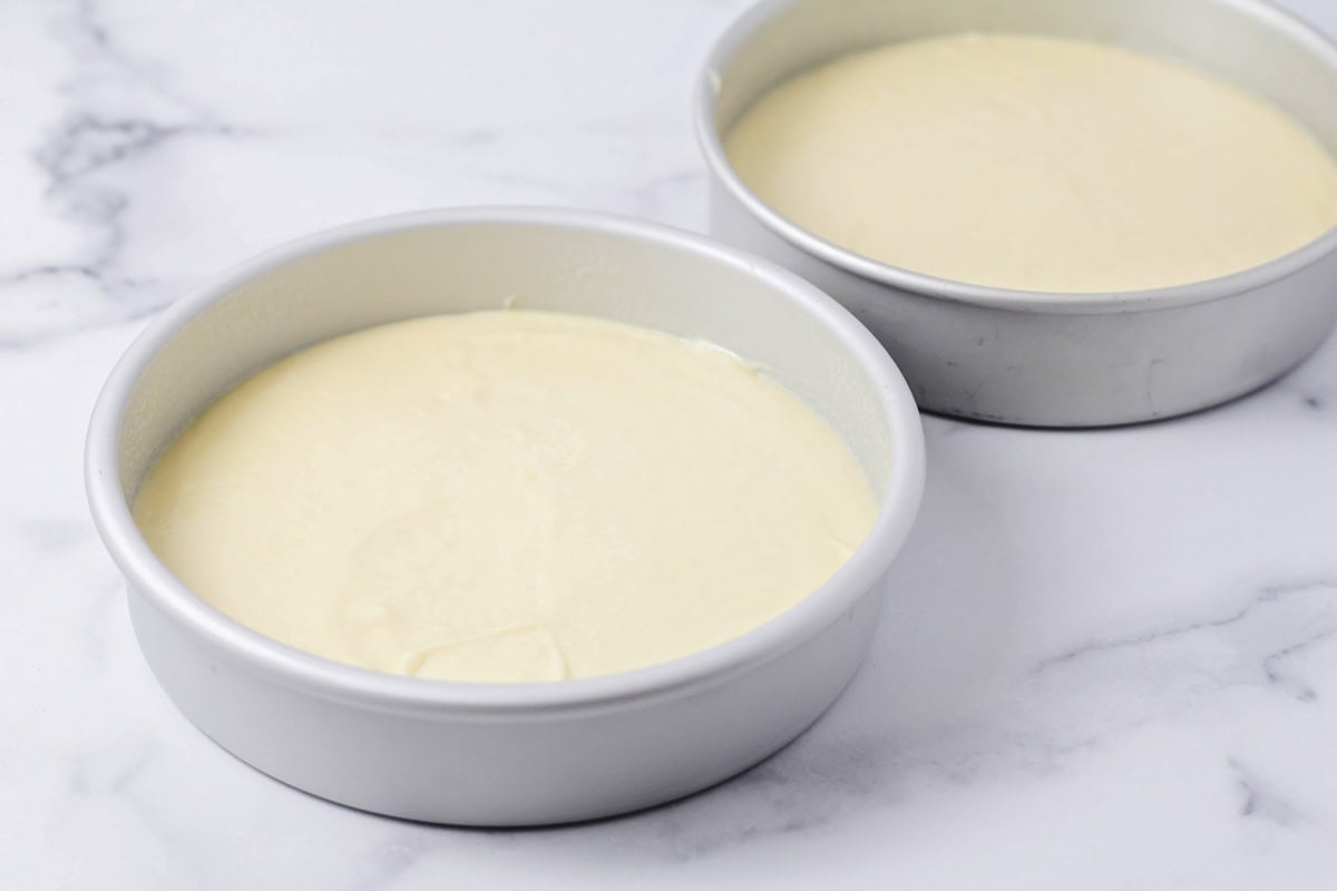 Cake batter poured into cake pans.