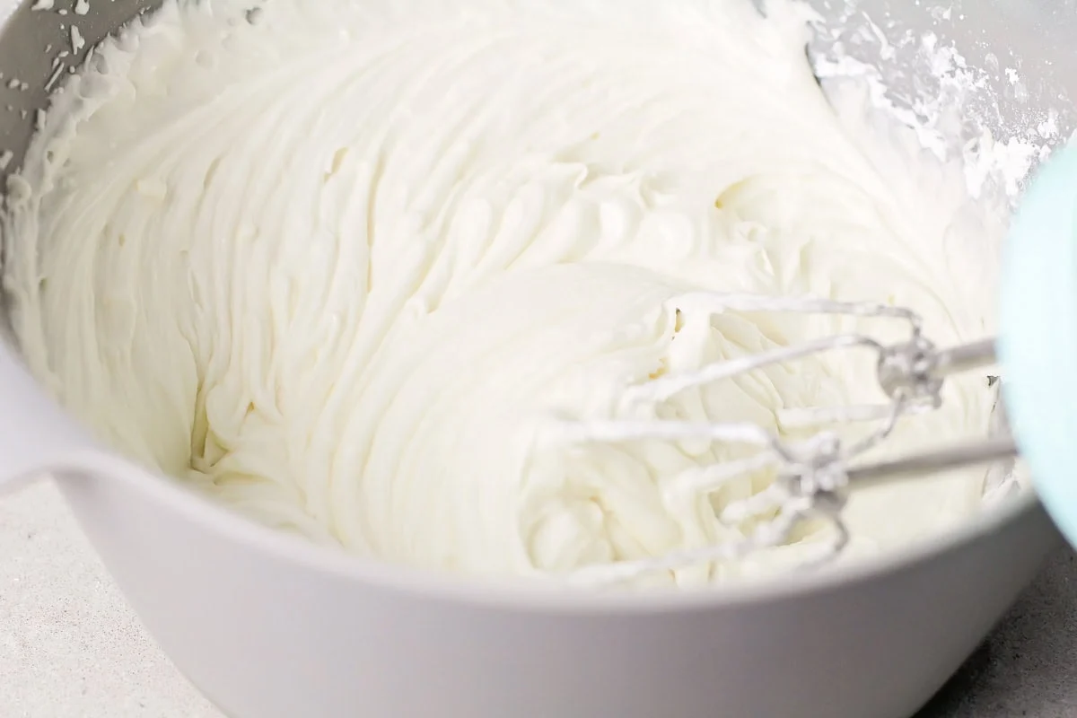 Whipping frosting in a metal bowl.