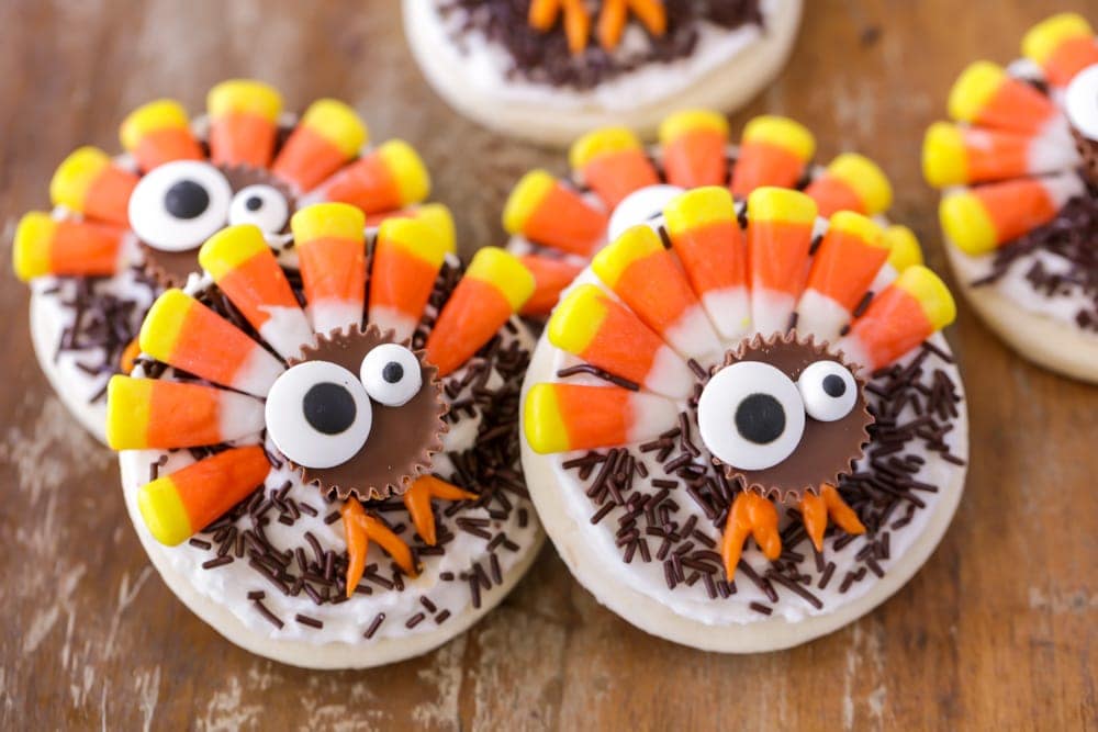 Sugar cookies with a turkey on top made out of a reeses cup, candy corn, and candy eyes. 