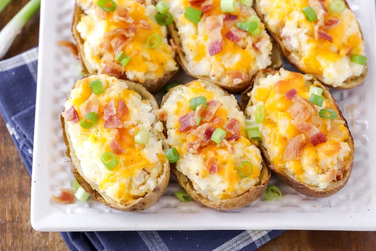 Photo of twice baked potatoes topped with melted cheese, back, and green onions