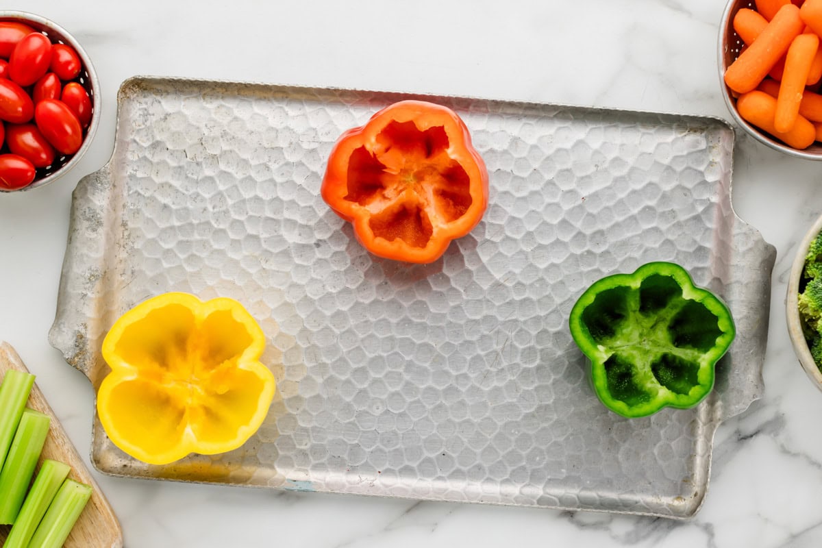 Hollowed out peppers placed on veggie tray .