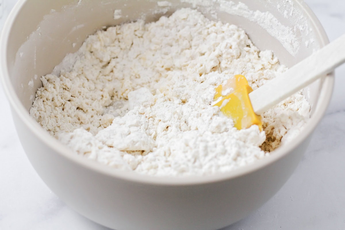 Mixing dough for Bunuelos in bowl.