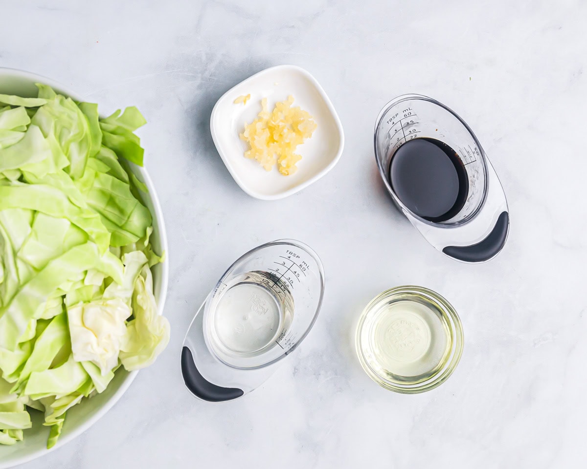 Cabbage and seasonings measured on a kitchen counter.