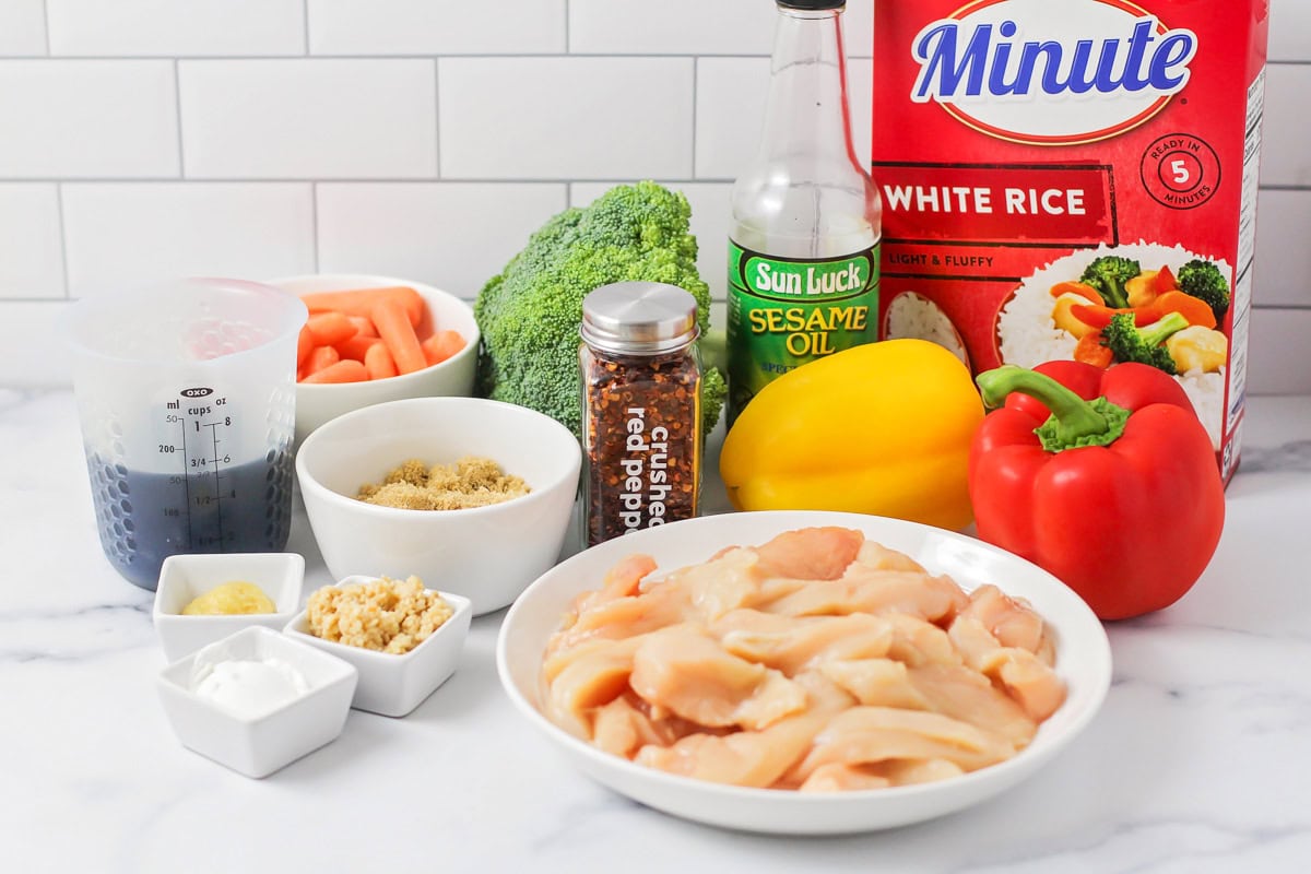 Cubed chicken, seasoning, and minute rice on the a kitchen counter.