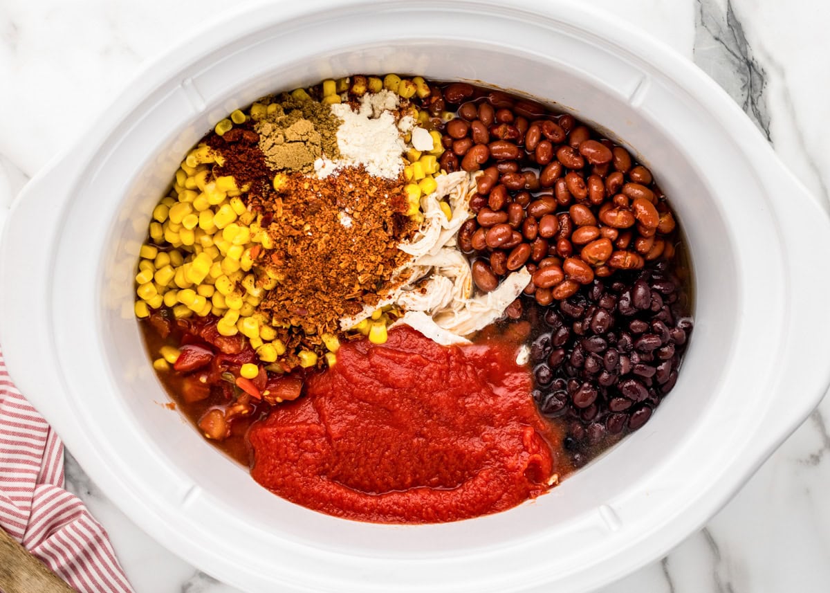 Ingredients for Chicken Taco Soup dumped into slow cooker.