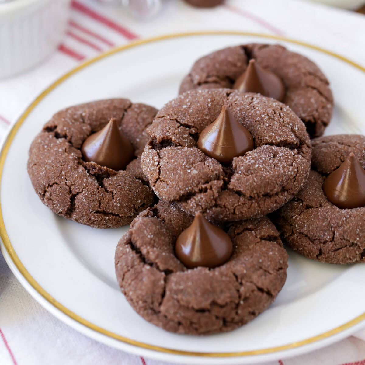 Chocolate kiss cookies stacked on white plate.