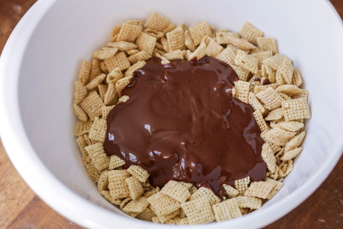 Chocolate poured over chex cereal in white bowl.