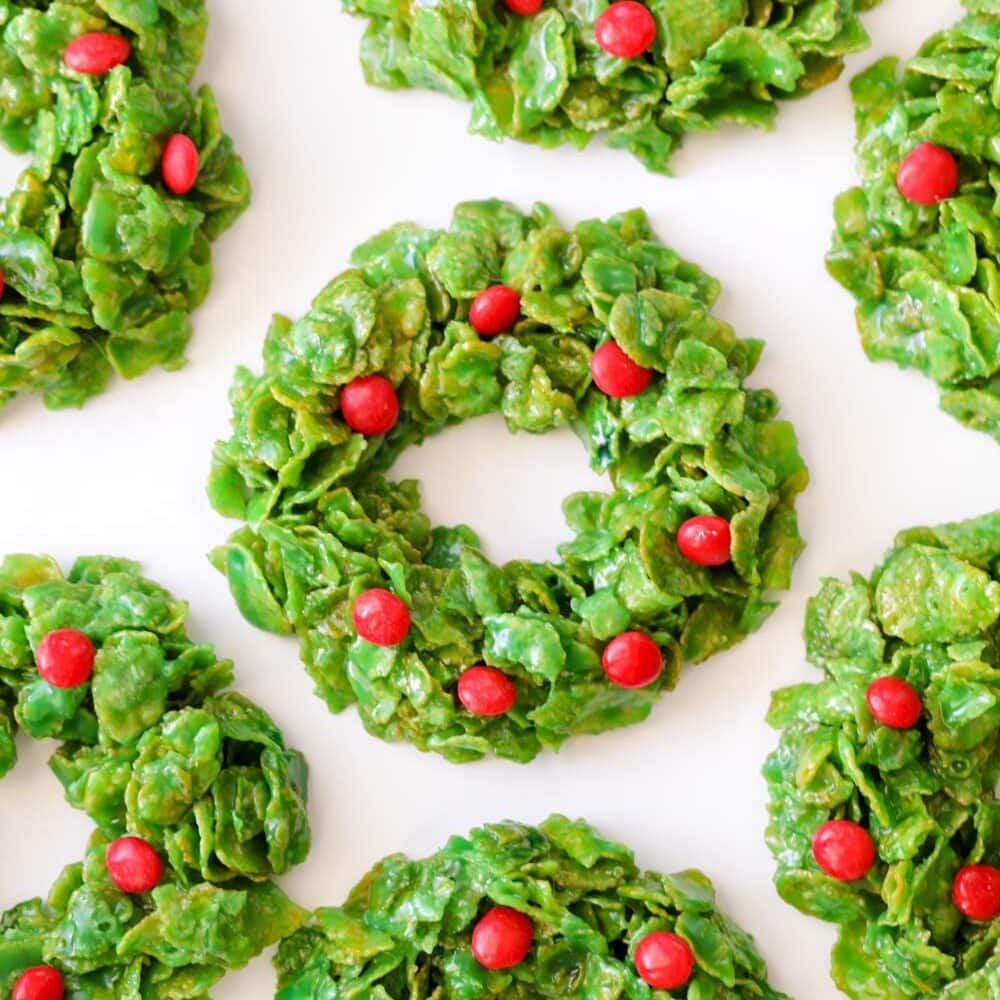 Christmas wreath cookies made from cornflakes on white parchment paper.