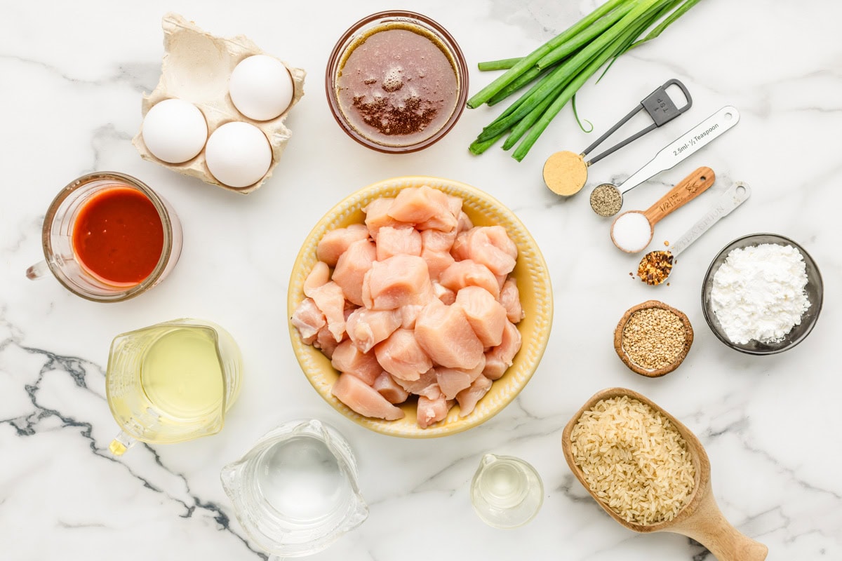 Cubed chicken, eggs, rice, and seasonings, measured and ready for cooking.