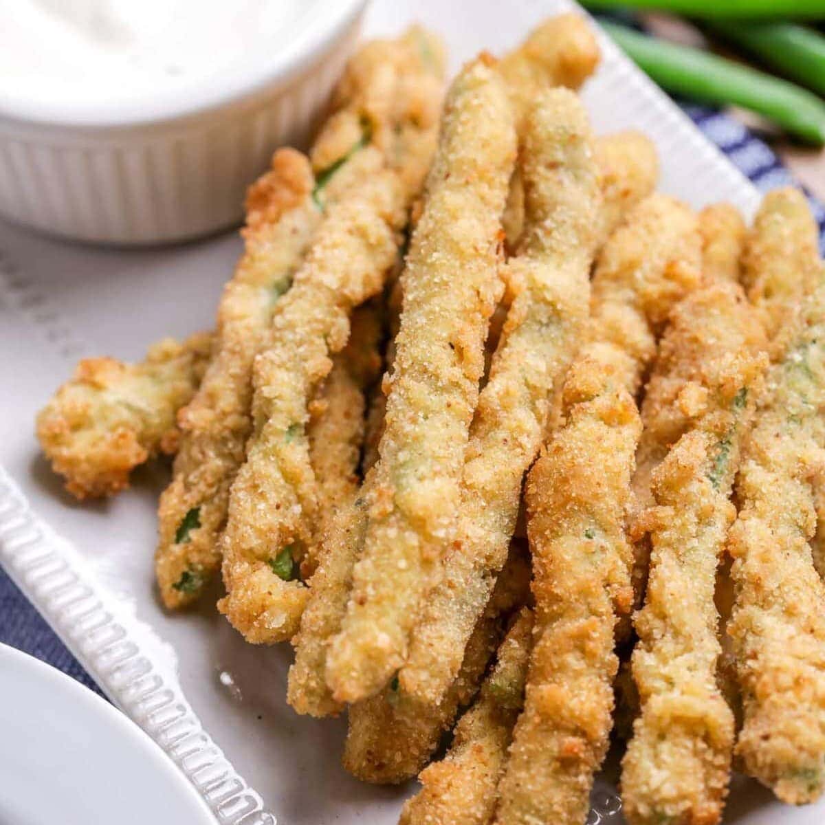 Fried green beans served with a side of ranch dressing.