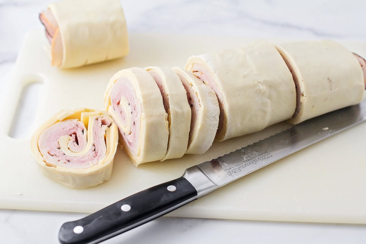 Cutting slices from the puff pastry log.