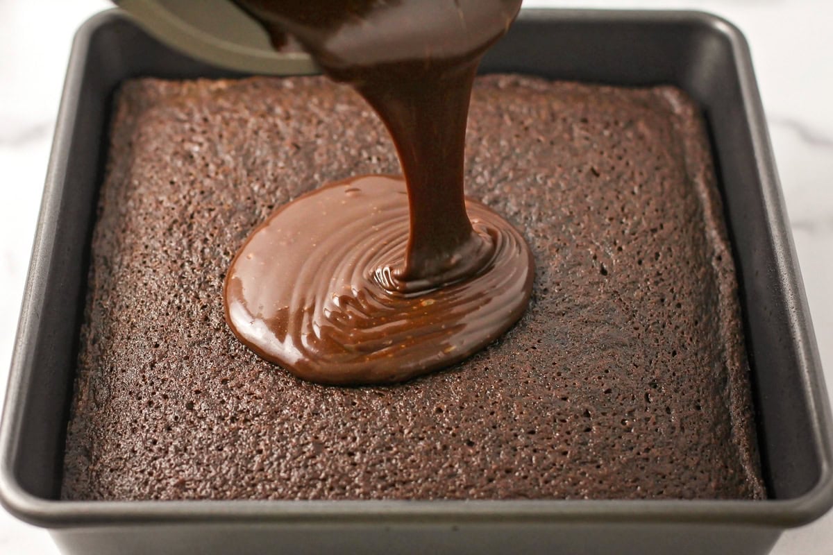 Pouring frosting on top of the baked caked.