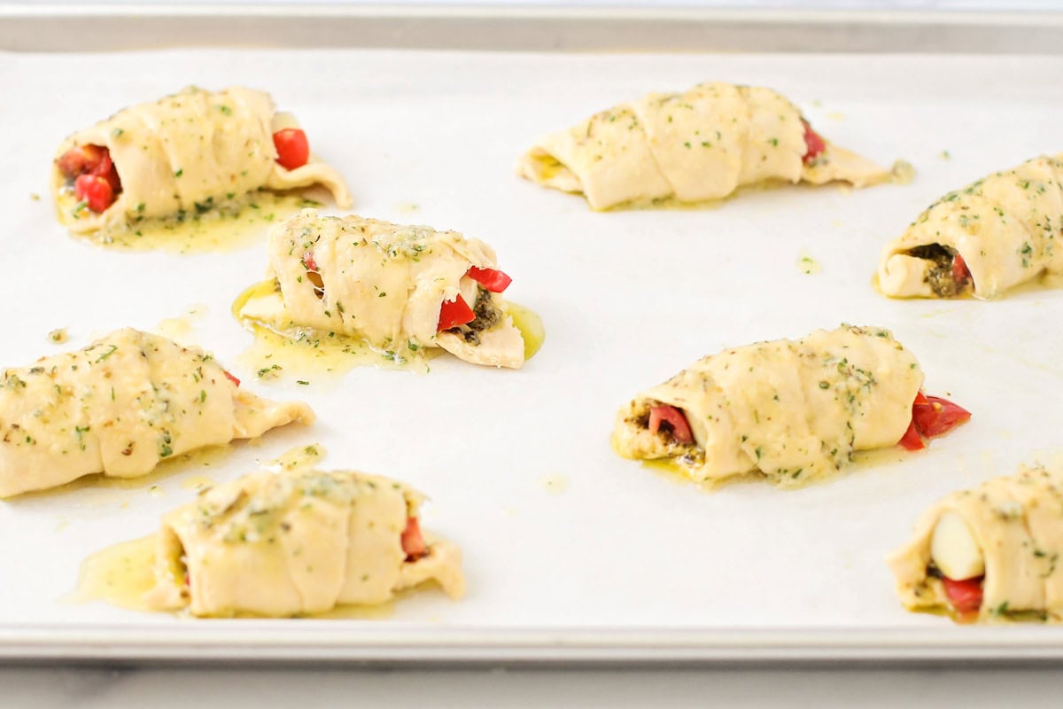 Topping the wrapped croissants with garlic butter.