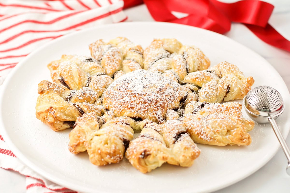 A puff pastry snowflake on a white plate.