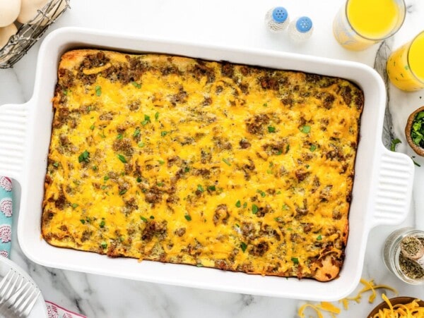 Sausage breakfast casserole baked in dish with ingredients around it.