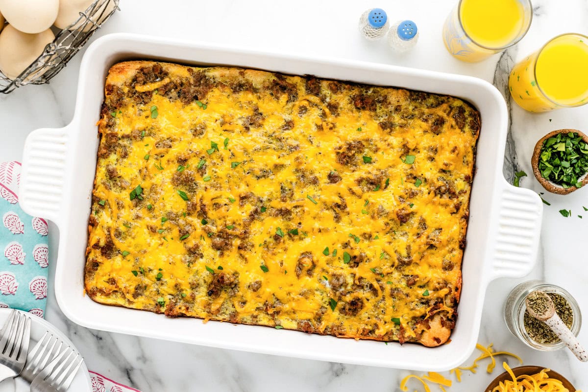 A baked sausage breakfast casserole in a white baking dish.