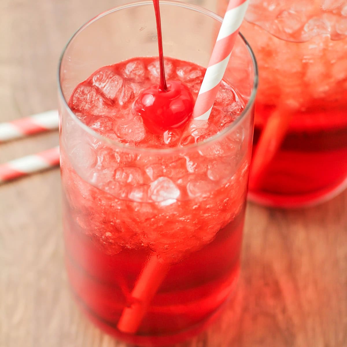 Shirley Temple drink close up image with ice and cherry in the cup.