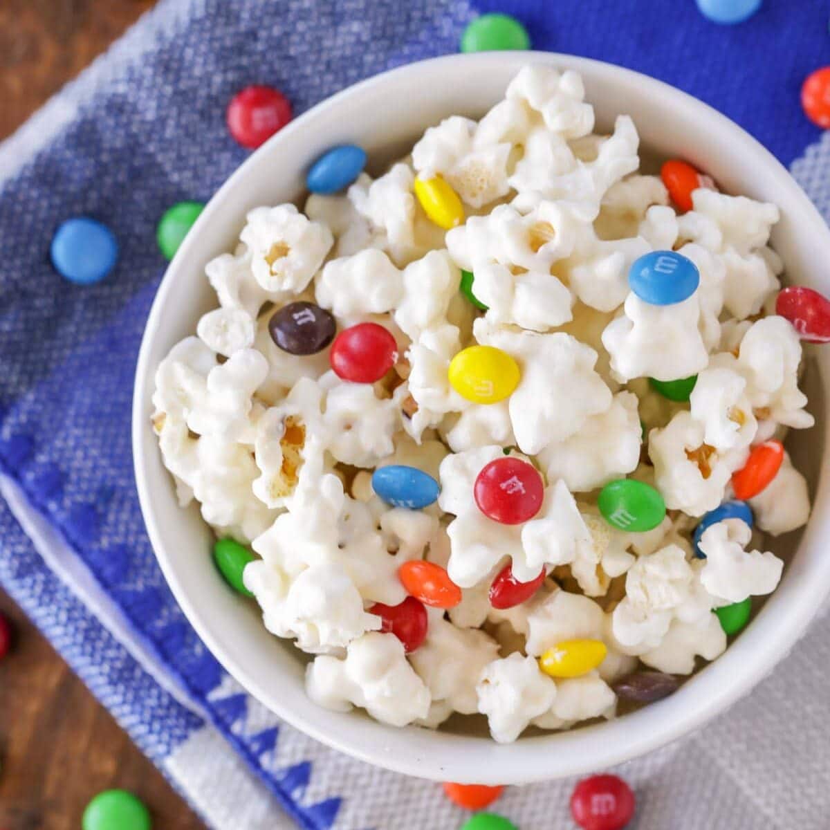 Close up image of white chocolate popcorn with M&Ms on top.