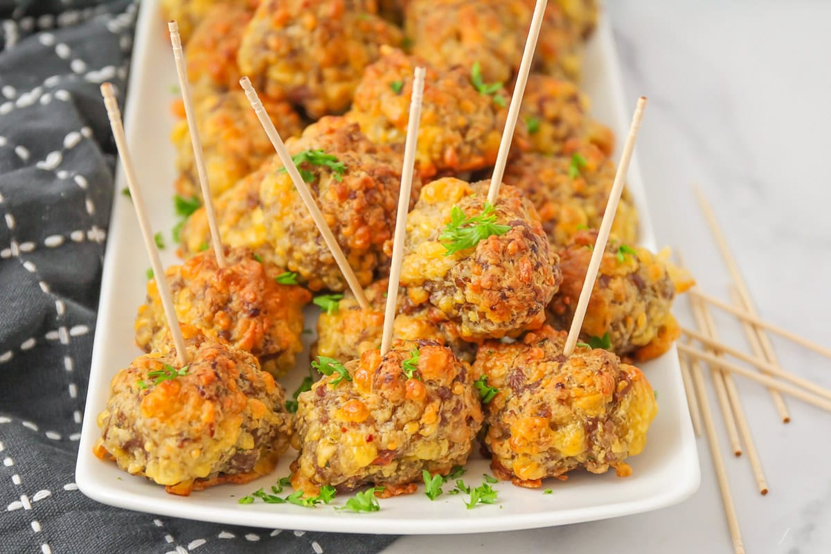 Bisquick sausage balls with toothpicks in them on white platter.