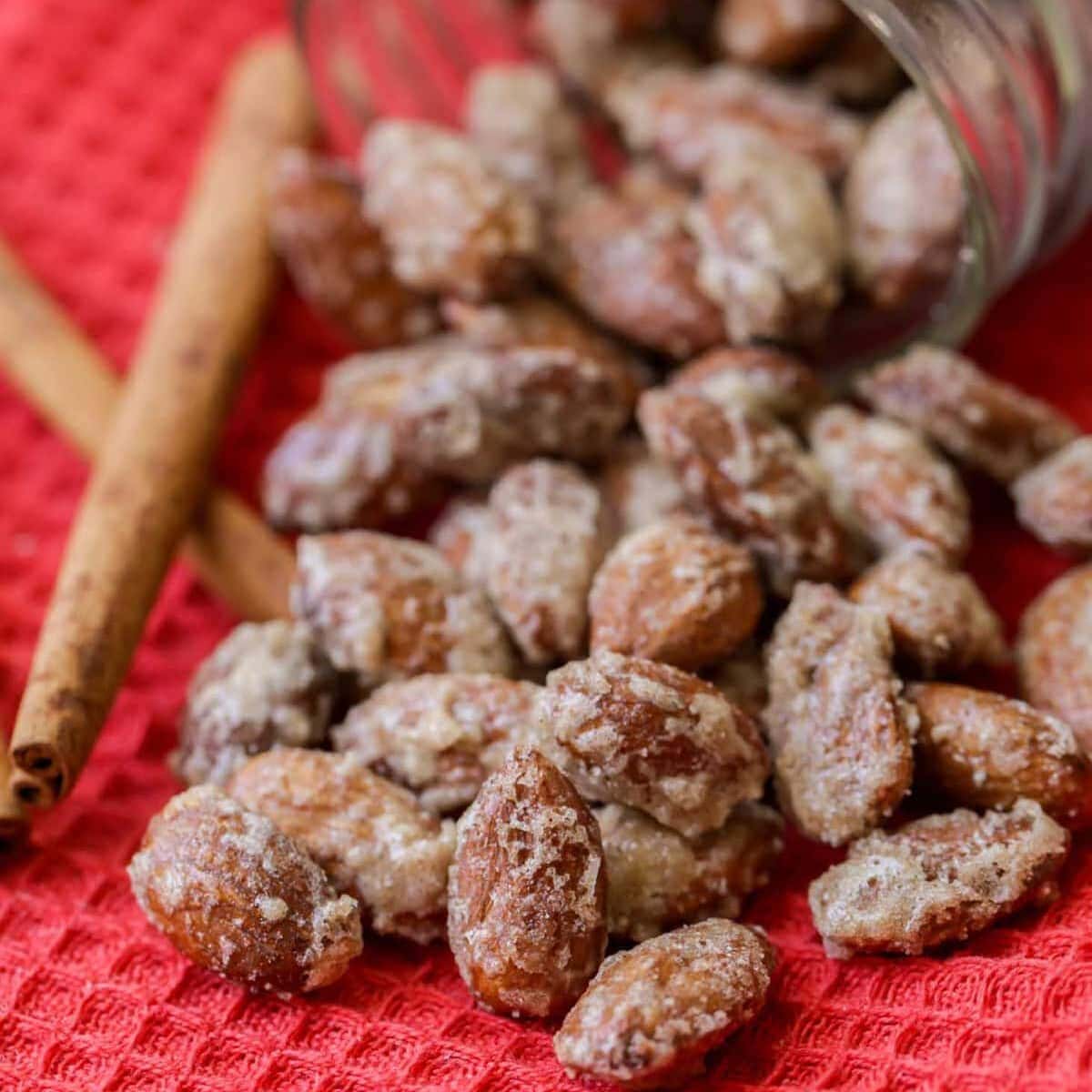 Candy coated almonds spilling from a glass mason jar.