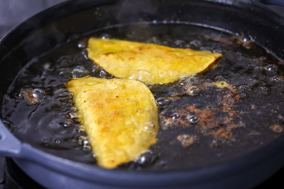 Chicken tacos recipe being fried in hot oil.