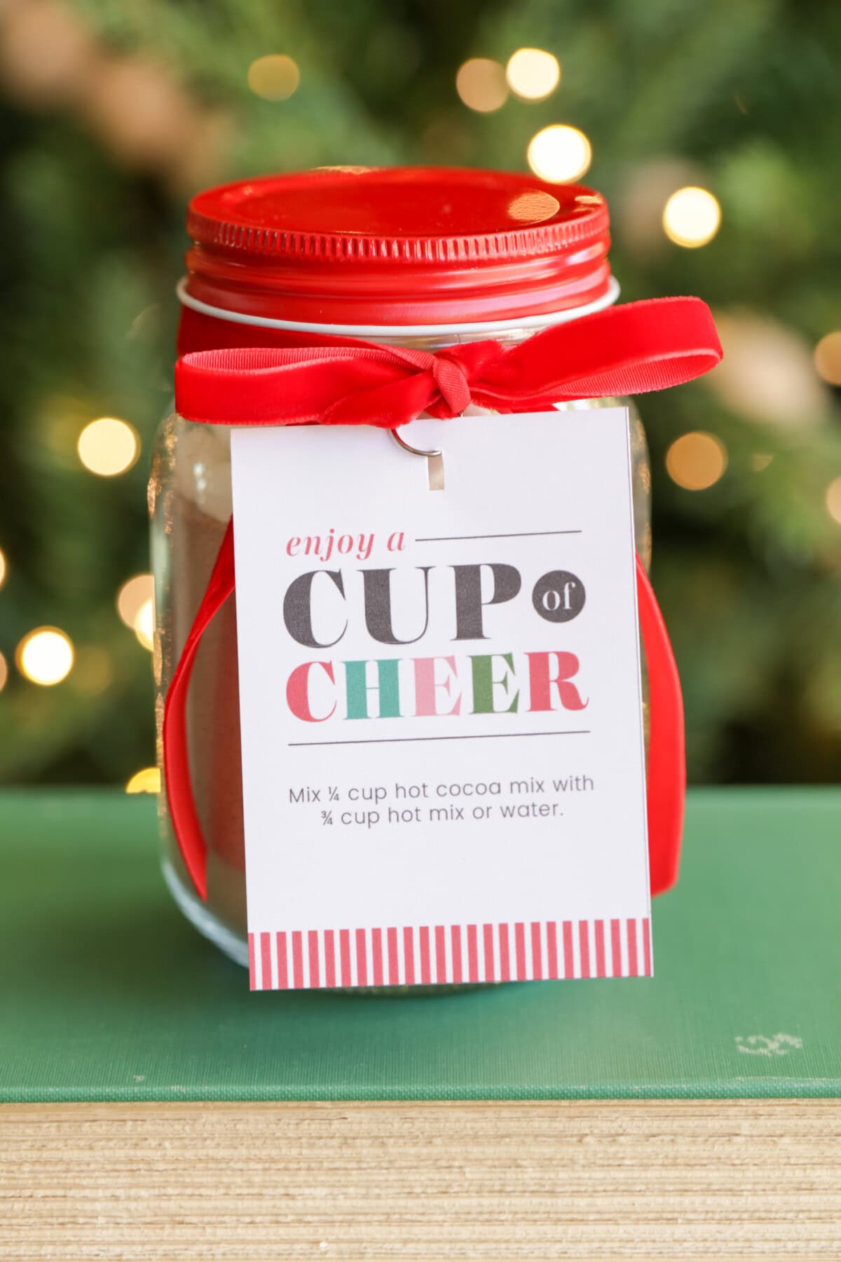 Cup of cheer gift tag attached to homemade hot cocoa.