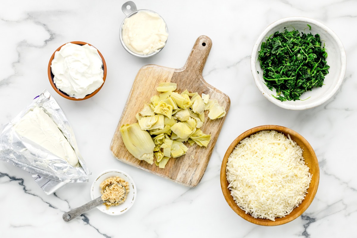 Ingredients for crockpot spinach artichoke dip on counter.