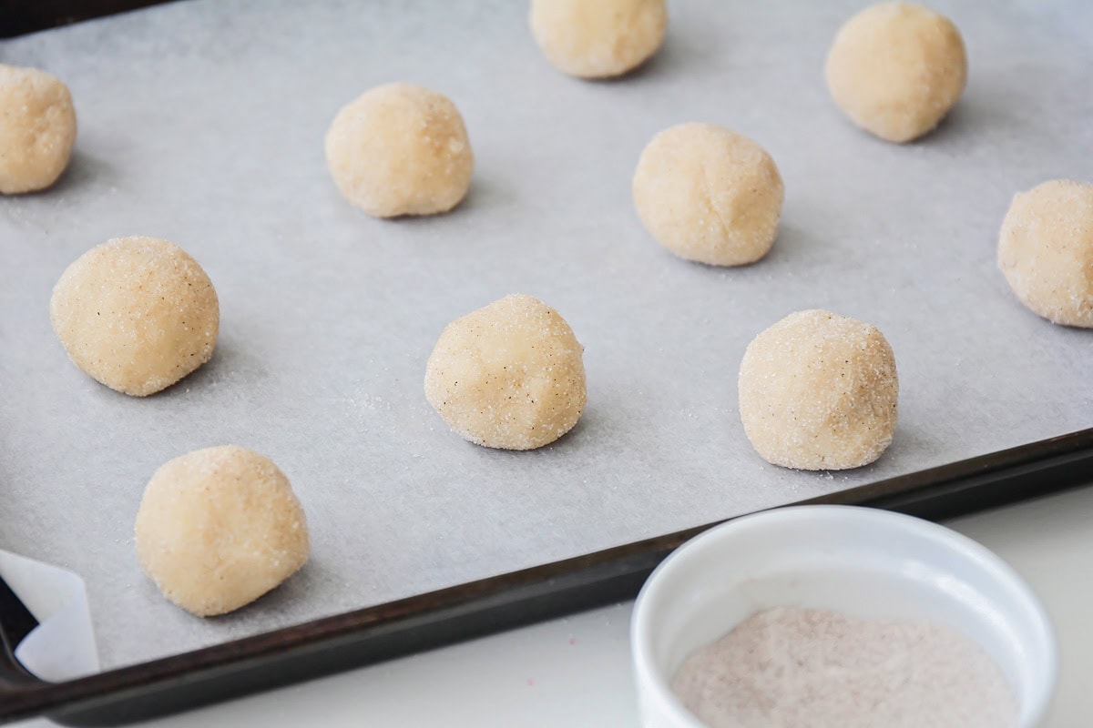 Rolled and dipped balls of eggnog snickerdoodles.