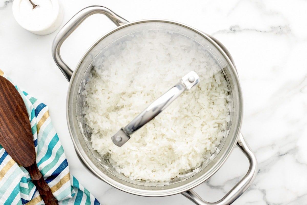 Rice cooking in a covered saucepan.