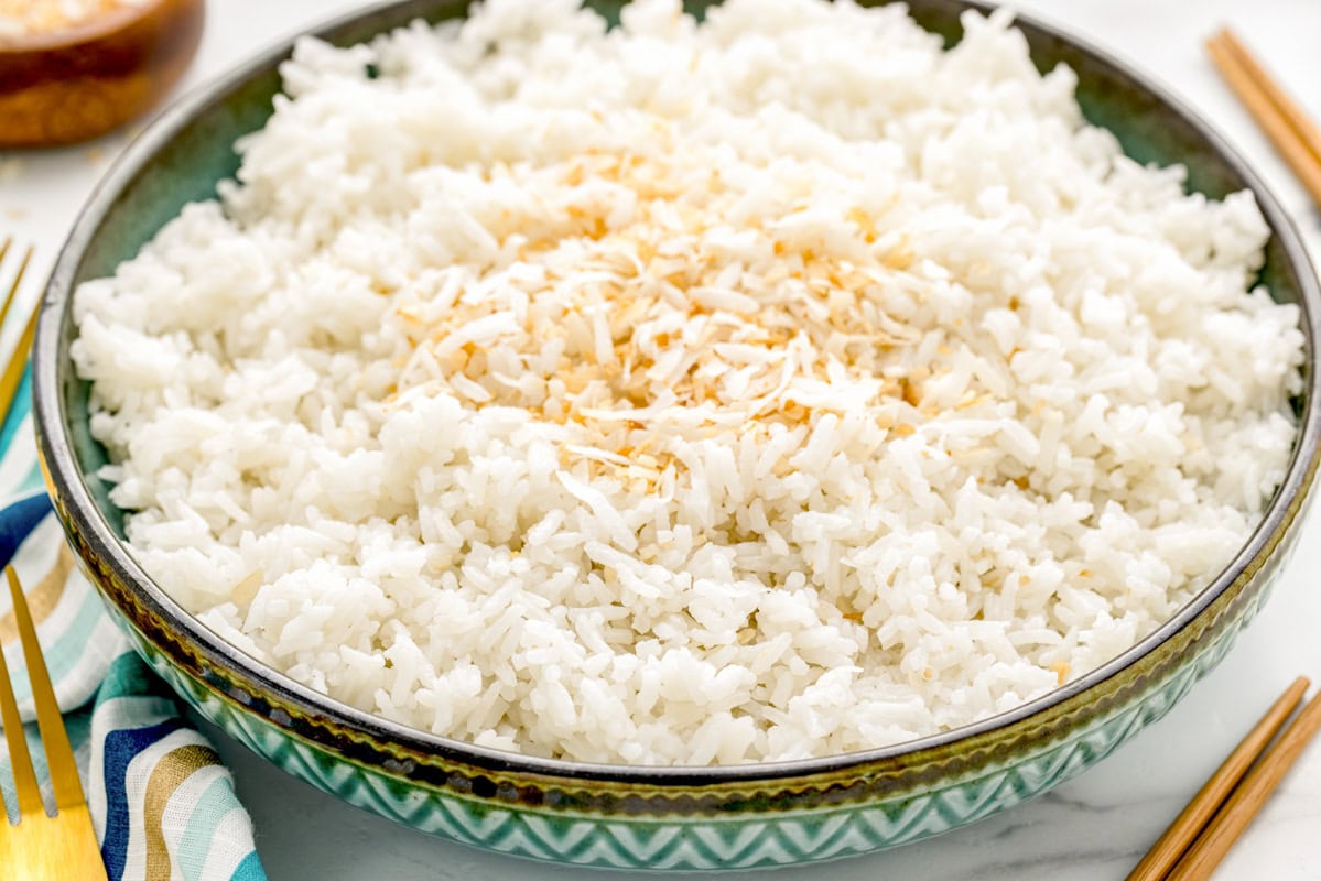 Coconut rice served in a decorative bowl with shaved coconut on top.