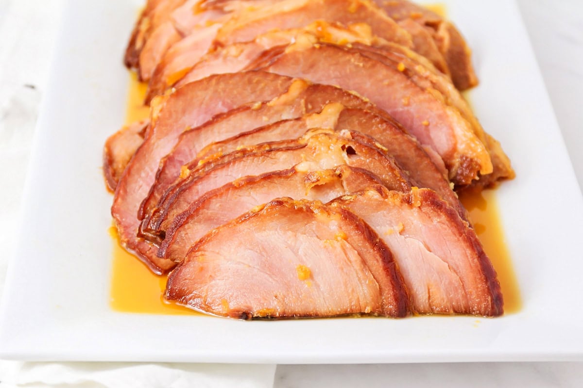 Slices of instant pot ham served on a white platter.