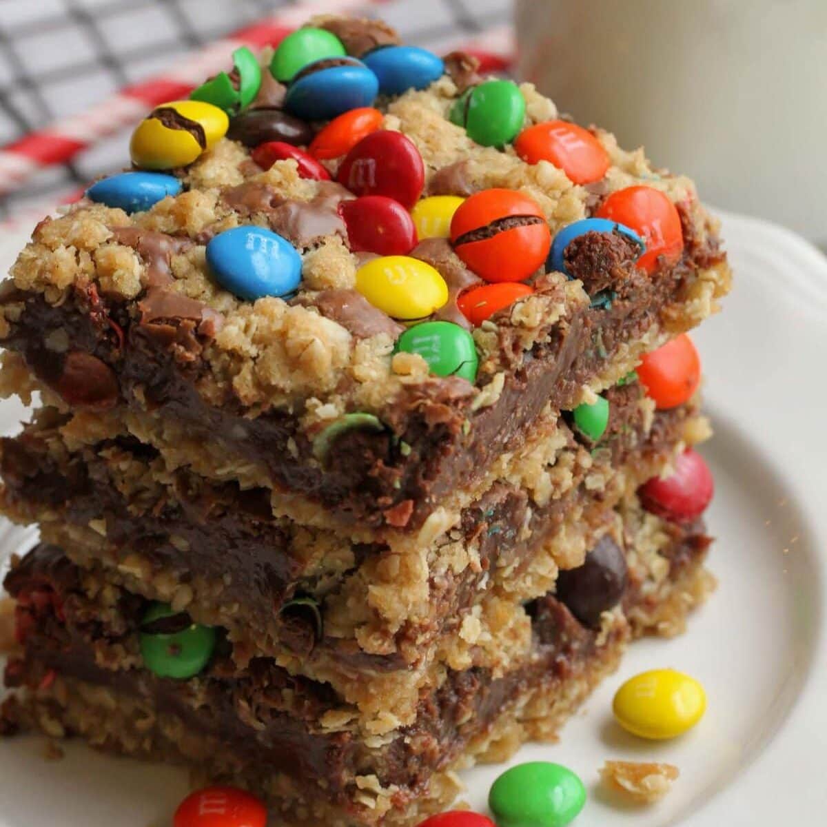 M&M chocolate bars stacked on top of each other on white plate.