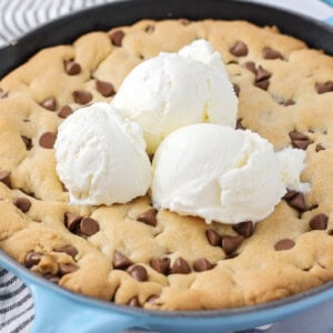 Easy Pizookie recipe cooked up in cast iron skillet with ice cream on top.