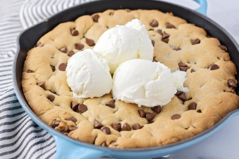 Easy Pizookie recipe cooked up in cast iron skillet with ice cream on top.