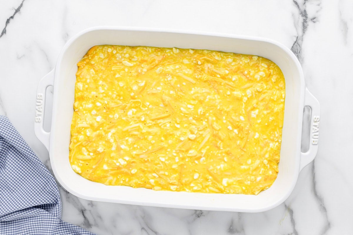 Egg and cheese mixture in a white baking dish.