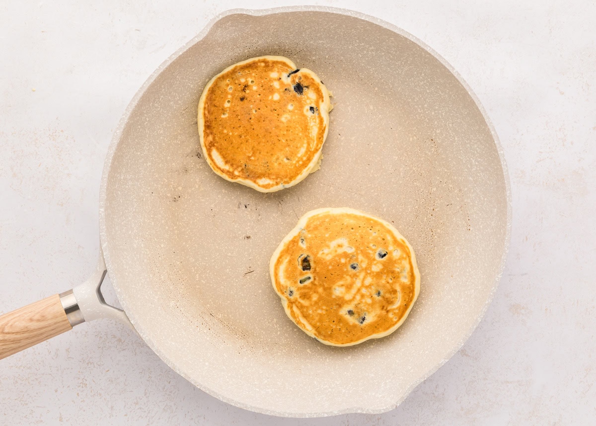 Two golden brown pancakes in a skillet.