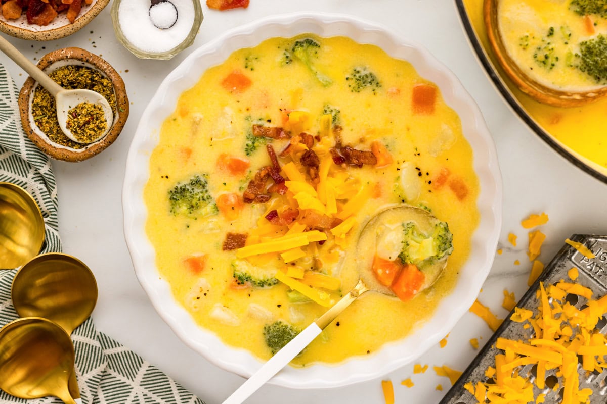 Bowl of broccoli cheddar potato soup with spoon in it.