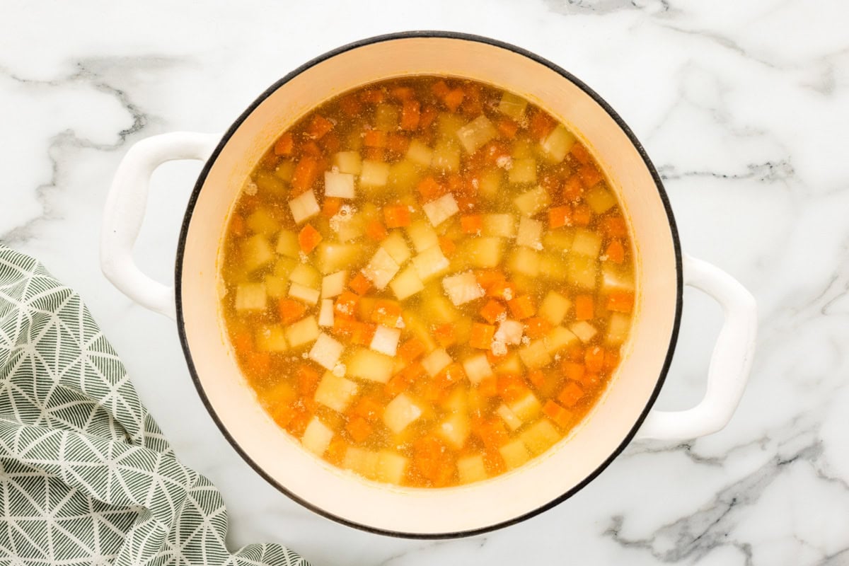 Chopped potatoes and carrots in bowl for soup recipe.